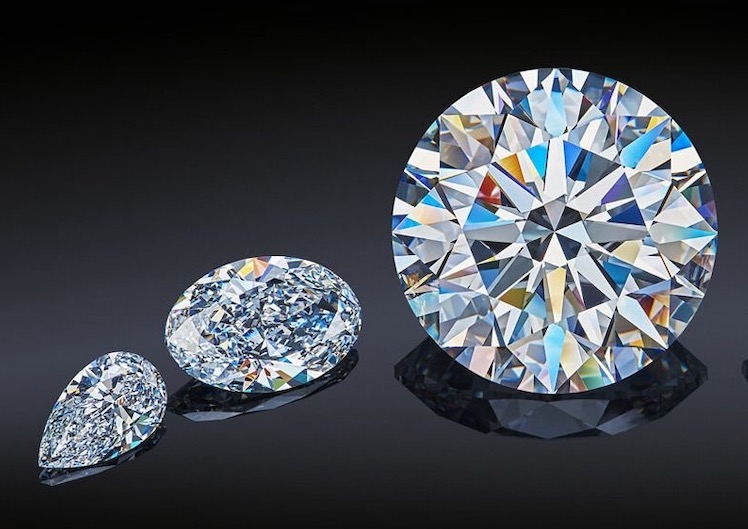 Three faceted round brilliant diamonds shown at different sizes